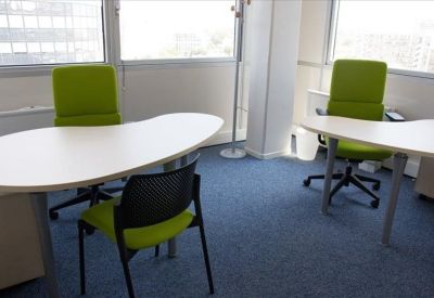 Bright internal office suite featuring white curved desks and vibrant lime green chairs.
