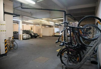 Secure underground parking area with bicycle racks and car spaces.