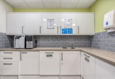 Kitchen area with modern appliances and green backsplash