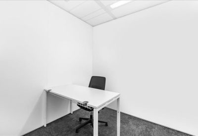 Modern meeting room with a U-shaped white table and green feature wall.