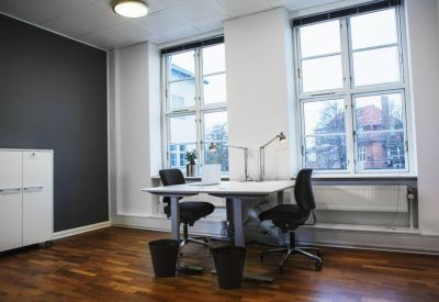 Private office space with wooden floors, two desks, and large windows.