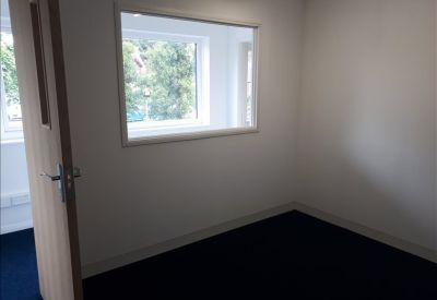 Private office space with navy blue carpet and an internal viewing window.