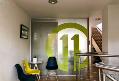 Lobby area featuring colorful chairs and a glass door with a large green circle and the number 11.
