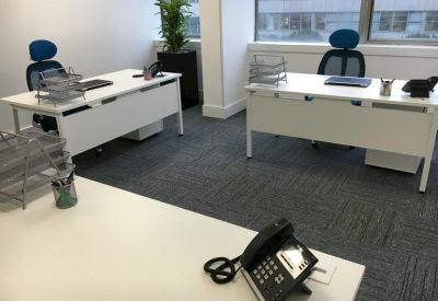Private office suite with two white desks, ergonomic blue chairs, and a large window.