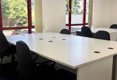 Office suite with large windows and white workstations.