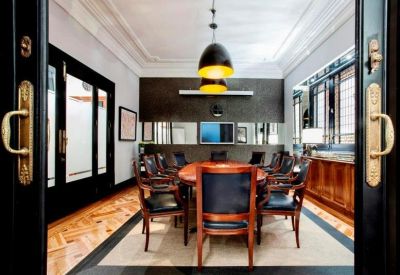 Sophisticated boardroom with a large oval table, leather chairs, and contemporary pendant lighting.