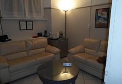 Reception or waiting area with leather seating and a warm floor lamp.