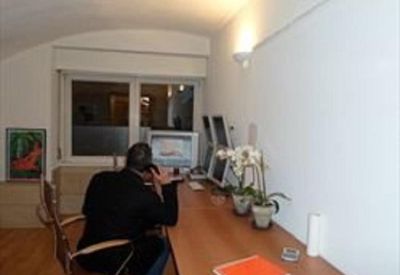 Private office featuring a long wooden desk, computer monitors, and indoor plants.