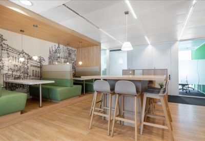 Communal dining area with booth seating, high-top tables, and a large architectural mural.