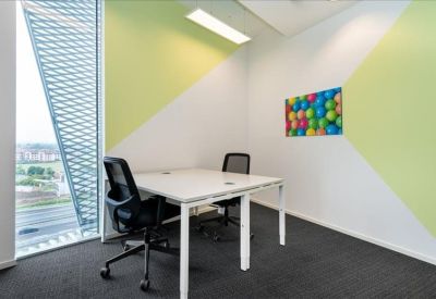 Bright private office featuring a geometric lime green feature wall and large window.