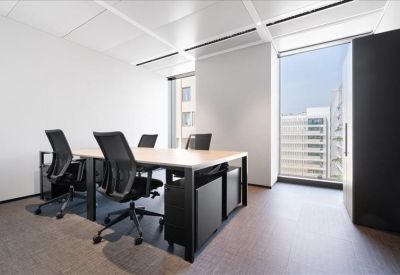 Private office space featuring a four-person desk arrangement and floor-to-ceiling window.