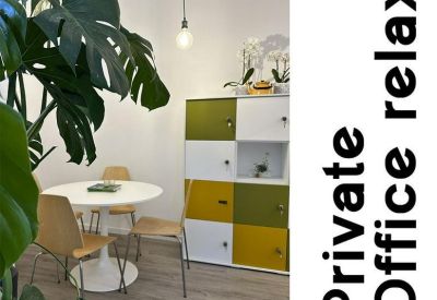 Relaxation zone with a small round table, colorful lockers, and a large Monstera plant.