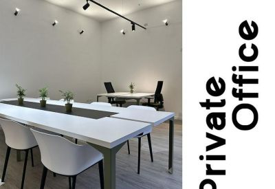 Private office suite with a long white desk, modern chairs, and track lighting.