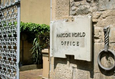 Stone entrance sign for Marconi World Office with iron gate.
