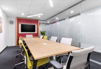 Modern office breakout area with a high white counter, wooden bar top, and hanging pendant lights.