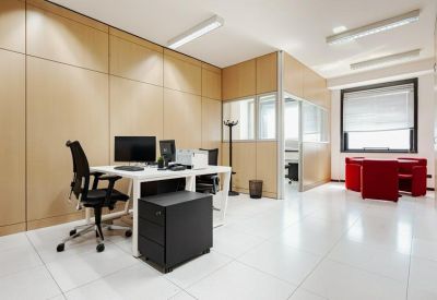 Private office featuring wood-paneled walls and a white workstation with black ergonomic chair.