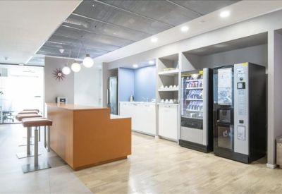 Modern breakout area featuring a wooden bar counter and vending machines.