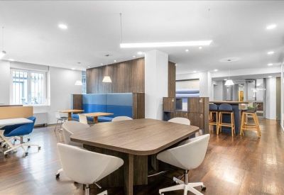 Open-plan communal area with various seating options and warm wooden flooring.