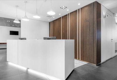 Sleek white reception desk positioned against a modern wood-paneled feature wall.