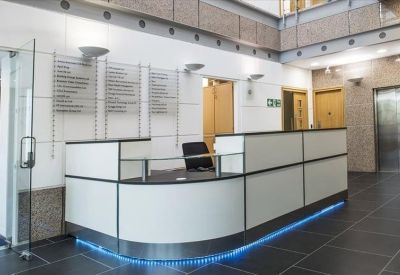 Modern reception desk with blue under-lighting and information directory.