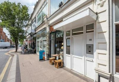 White private entrance door with a small overhead canopy on a paved sidewalk.