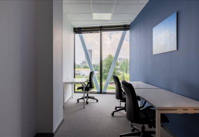 Compact two-person office with a blue feature wall and natural light.