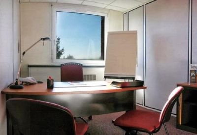 Private office suite with a wooden desk, red chairs, and a whiteboard.