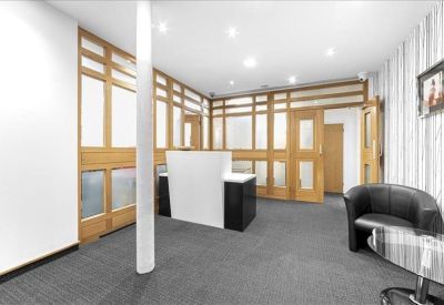 Bright reception area with white desk, wooden accents, and tall white pillar.