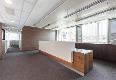 Modern reception desk area with dark wood accents and large windows.