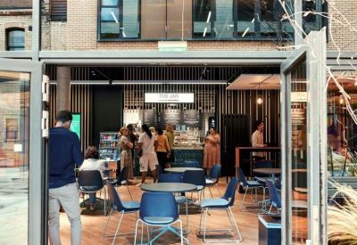 Internal cafe and kiosk area with wooden wall paneling and blue seating.