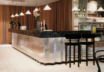 Sleek reception desk with metallic panels and dark stone countertop.