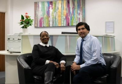 Reception area with a staff member and colorful abstract artwork.