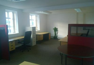 Professional office space with red partitions, desks, and a meeting table.