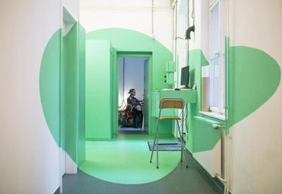 Modern hallway with a unique green circular wall graphic and a small computer workstation.