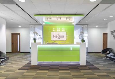 Brightly lit reception area with a vibrant lime green front desk and modern seating.