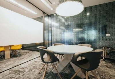 Small meeting room with round table and textured glass partition.