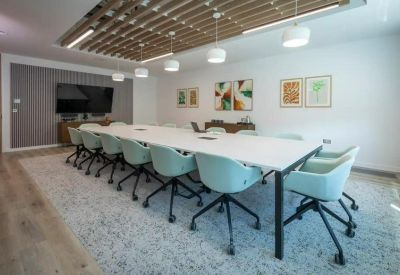 Bright boardroom with a long white table, teal chairs, and a slatted timber ceiling feature.