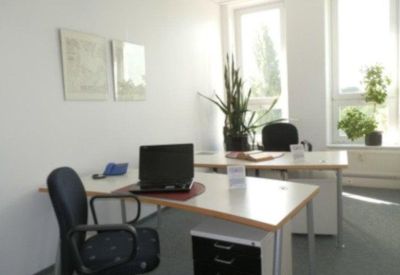 Private office with two desks and large windows.