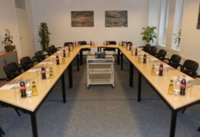 Meeting room with U-shaped table setup and refreshments.
