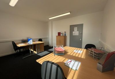 Private office suite featuring a desk, office chair, and wooden cabinet.