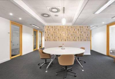 Contemporary breakout space featuring a round table and a patterned feature wall.