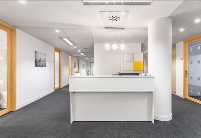 Minimalist white reception desk in a bright corridor with a cylindrical pillar.