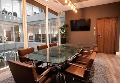 Meeting room with glass walls and brown chairs.