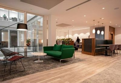 Open communal space with green sofas and seating areas.