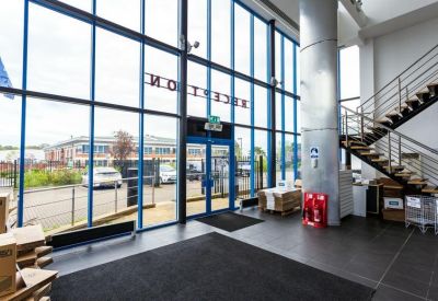 Spacious reception area with high ceilings and tall glass windows.
