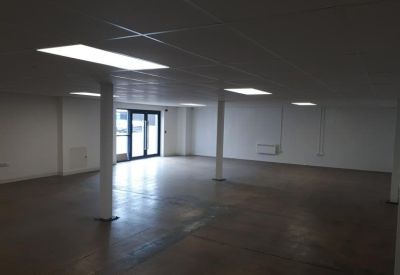Empty office floor with natural light coming through glass entrance doors.