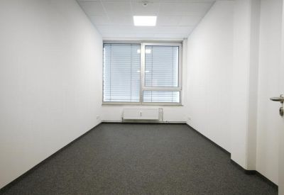 Private internal office suite with grey carpeting and a large window providing natural light.