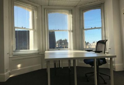 Bright office suite with large bay windows and a white desk.