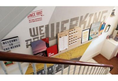 Internal staircase featuring branded wall graphics and a notice board.