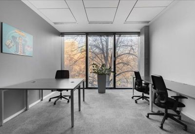 Bright private office suite with two desks and a view of autumn trees.